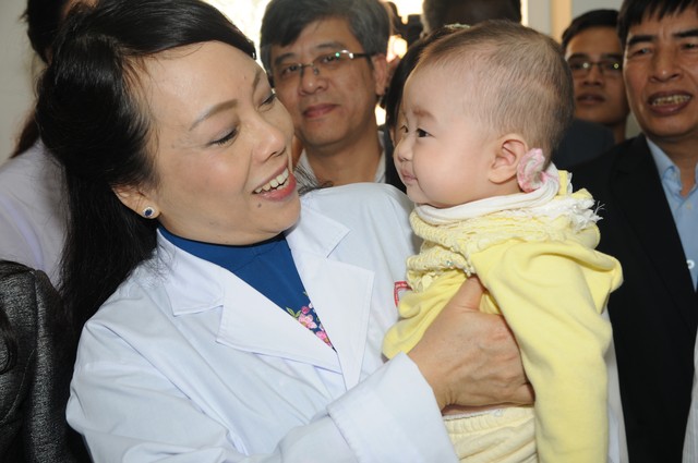 Bộ trưởng Bộ Y tế Nguyễn Thị Kim Tiến ân cần quan tâm em bé đi tiêm chủng tại trạm y tế xã Song Mai- TP Bắc Giang